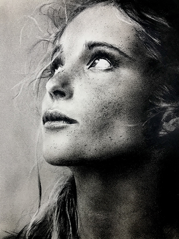 Charcoal drawing of a young woman looking up